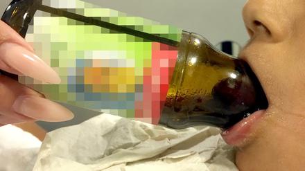 Die Zunge des Jungen in der Saftflasche.