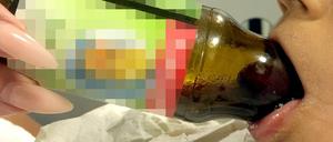 Die Zunge des Jungen in der Saftflasche.