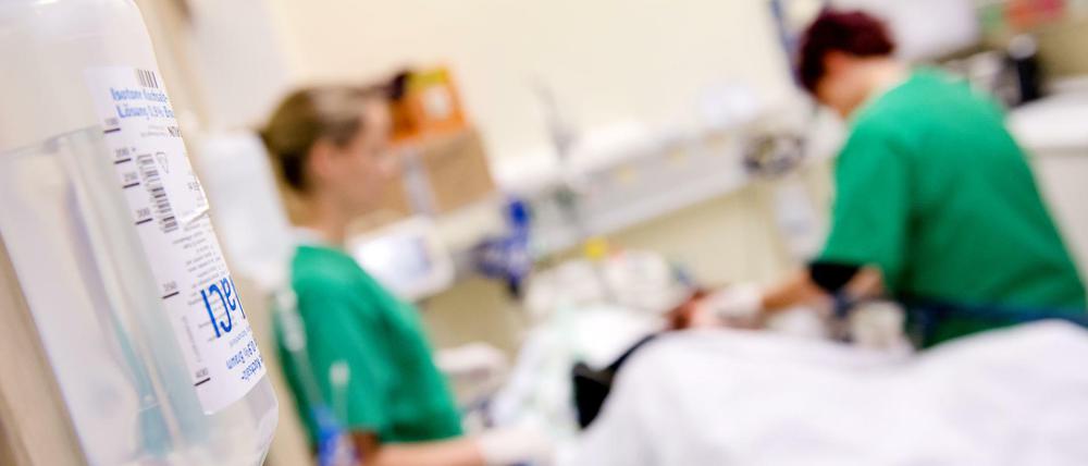 Medizinisches Personal versorgt in einem Krankenhaus einen Patienten.