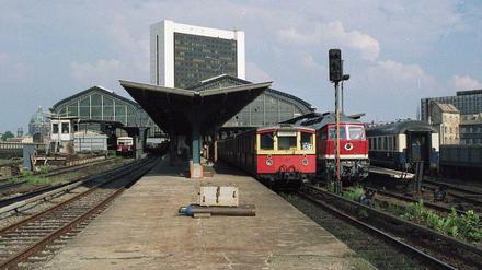 Der Bahnhof Friedrichstraße im November 1989. Die rechte Halle ist für West-Züge, die linke für die S-Bahn der DDR. Links: Sichtschutz und Grenzhäuschen.