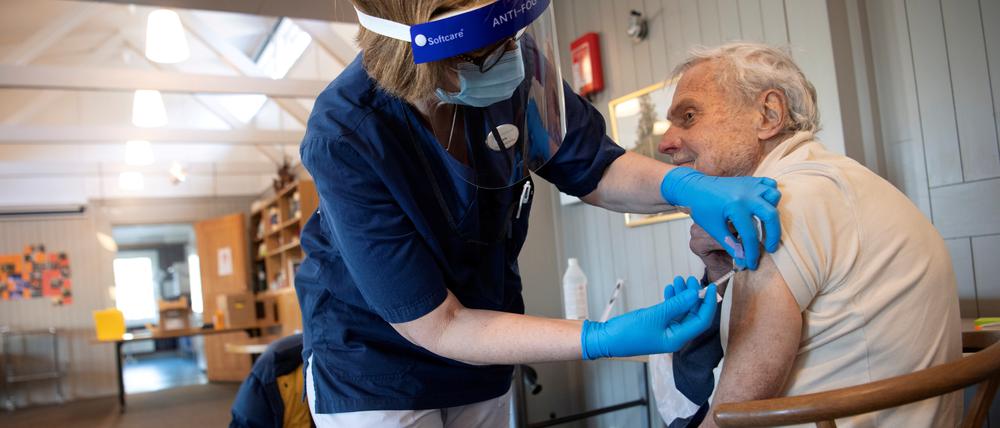 FILE PHOTO: A health worker vaccinates an elderly person with Pfizer's COVID-19 vaccine at a temporary vaccination clinic in a church in Sollentuna, north of Stockholm, Sweden March 2, 2021. Fredrik Sandberg/TT News Agency/via REUTERS ATTENTION EDITORS - THIS IMAGE WAS PROVIDED BY A THIRD PARTY. SWEDEN OUT. NO COMMERCIAL OR EDITORIAL SALES IN SWEDEN/File Photo