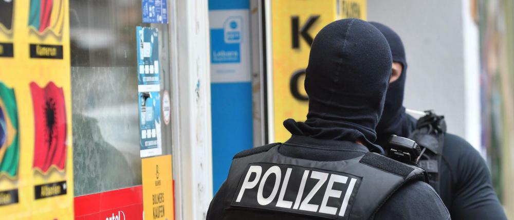 Vermummte Einsatzkräfte stehen vor einem Kiosk im Stadtteil Berlin-Neukölln. Behörden kämpfen inzwischen bundesweit vernetzt gegen Clans.