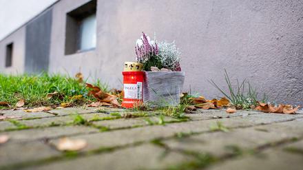 Eine Kerze und eine Blume stehen vor dem Tatort in Detmold. 