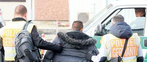 Polizisten begleiten einen Mann, der abgeschoben werden soll (Archivbild).