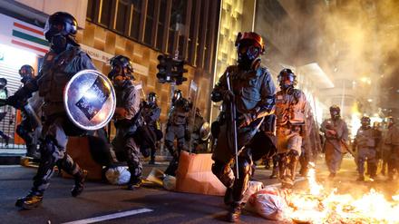 Aufruhr in Hongkong: Polizisten an einer brennenden Barrikade, die Demonstranten errichtet hatten