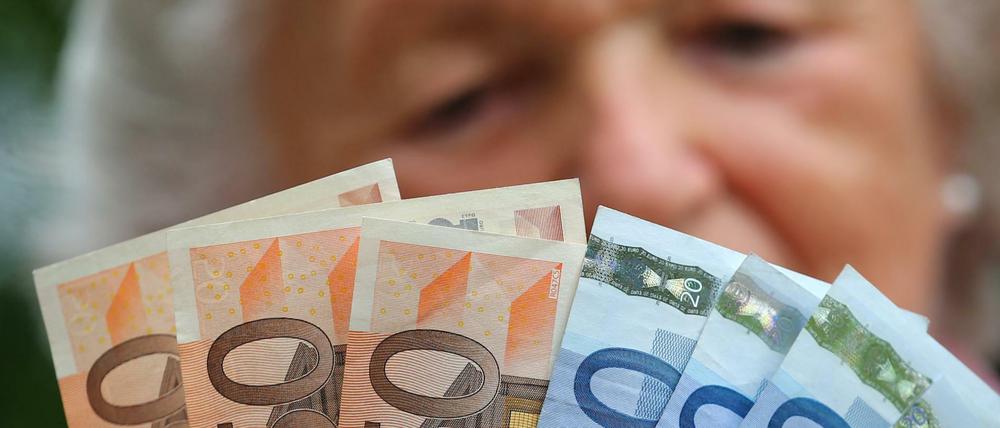 Was ist zum Leben nötig? Eine ältere Frau mit Geldscheinen, die nicht lange reichen werden.
