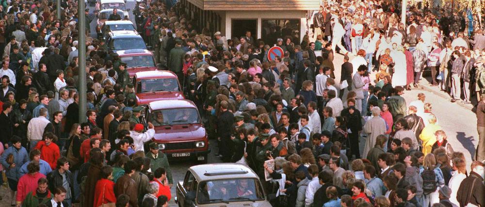 Eine Fahrzeugkolonne schiebt sich am 10.November 1989 in Richtung West-Berlin vorbei am Checkpoint Charlie.