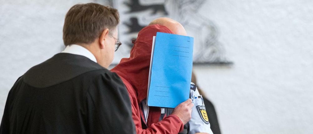 Der Angeklagte wird von einem Justizbeamten in einen Gerichtssaal des Landgerichts Stuttgart geführt.