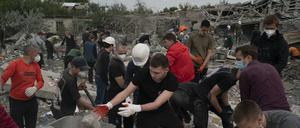 Freiwillige Helfer arbeiten in der Ukraine an der Beseitigung von Trümmern, nachdem mehrere Häuser nach einem Angriff auf ein Wohngebiet zerstört wurden.