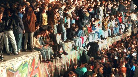 Menschen sitzen auf der Berliner Mauer - allerdings am 11.11.1989.