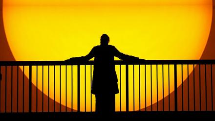 Die Silhouette einer Frau vor der Projektion einer gigantischen Sonne. Die Installation von Olafur Eliasson war erstmals 2003 in der Tate Modern zu sehen.. 