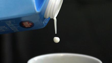 Tröpfchenweise fließt Milch aus einer Milchpackung (Illustration). 