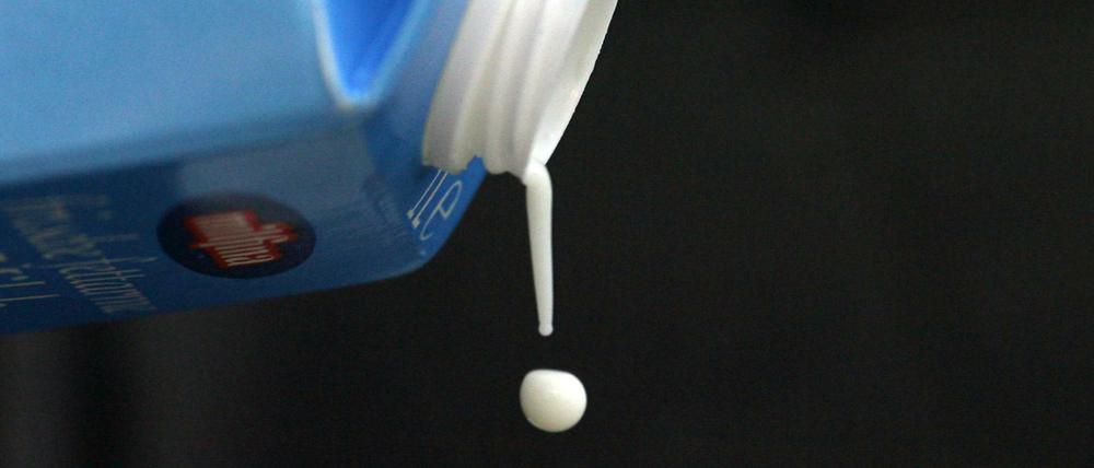 Tröpfchenweise fließt Milch aus einer Milchpackung (Illustration). 