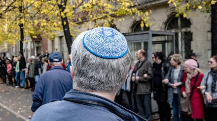 Ein Mann mit Kippa steht vor der Neuen Synagoge vor einer Menschenkette des Bündnisses für ein weltoffenes und tolerantes Berlin.