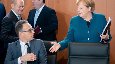 Heiko Maas (SPD), Außenminister, und Bundeskanzlerin Angela Merkel (CDU) begrüßen sich zu Beginn der Sitzung des Bundeskabinetts im Bundeskanzleramt.