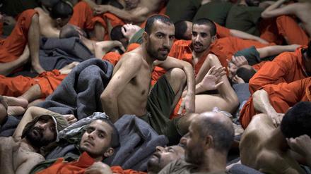 Männer, die als IS-Kämpfer gelten, sitzen in einem Gefängnis in Syrien.