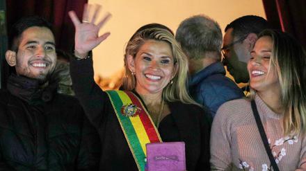 Boliviens Senatorin Jeanine Anez (M) trägt die Schärpe des Präsidenten und spricht vom Balkon des Quemado-Palastes winkend zu den Menschen. Nach dem Rücktritt von Boliviens Staatschef Morales hat sich die Senatorin zur Interimspräsidentin erklärt.