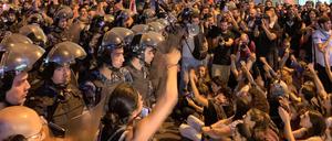 Sicherheitskräfte und Demonstranten stehen sich gegenüber.