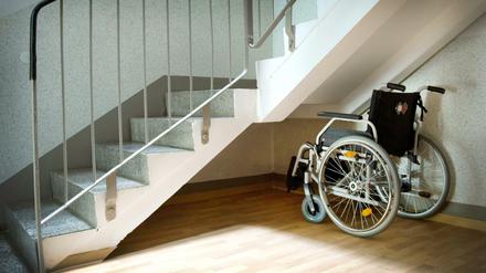 Ein Rollstuhl steht unter einer Treppe in einem Wohnhaus (Symbolbild).