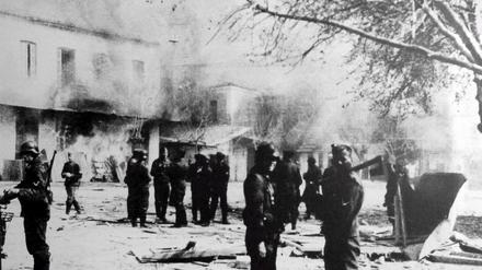 Distomo 1944. Das Foto eines deutschen Teilnehmers zeigt seine Kameraden vor den brennenden Häusern nach dem Massaker an 218 Menschen.