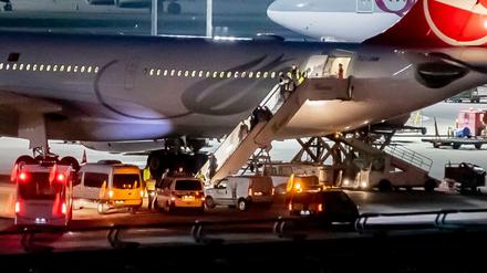 Polizisten begleiten die Abgeschobenen am Flughafen Tegel aus dem Flugzeug.