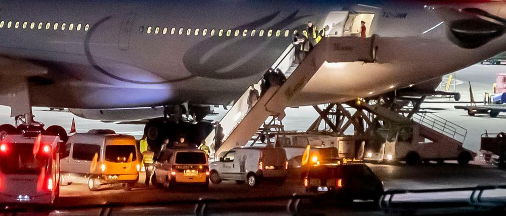 Polizisten begleiten die Abgeschobenen am Flughafen Tegel aus dem Flugzeug.
