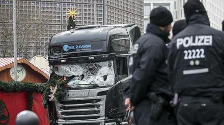 Polizisten stehen am 20. Dezember 2016 vor dem zerstörten Lkw am Weihnachtsmarkt am Breitscheidplatz in Berlin. 