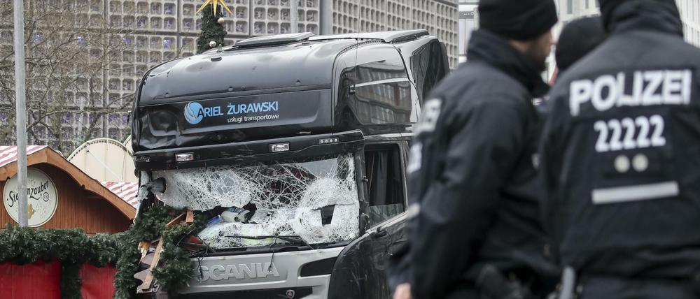 Polizisten stehen am 20. Dezember 2016 vor dem zerstörten Lkw am Weihnachtsmarkt am Breitscheidplatz in Berlin.