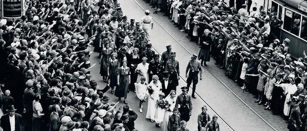 130 frisch verheiratete Paare der „Deutschen Christen“ (DC) auf einer Parade im August 1933 in Berlin. Spektakuläre Massenevents wie diese Massentrauung gab es viele, die völkische DC griff Bastionen der „alten Kirche“ an.