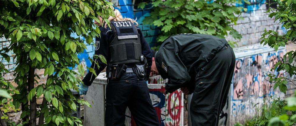 Polizeibeamte suchen im Görlitzer Park nach versteckten Drogen.