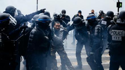 Ein Demonstrant wird von Polizisten festgehalten.