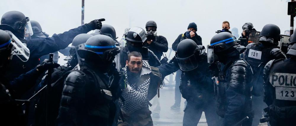 Ein Demonstrant wird von Polizisten festgehalten.