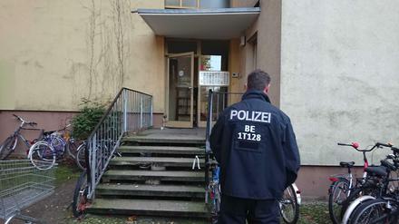 Ein Polizist steht vor dem Eingang des Wohnhauses, in dem der Terrorverdächtige lebte.