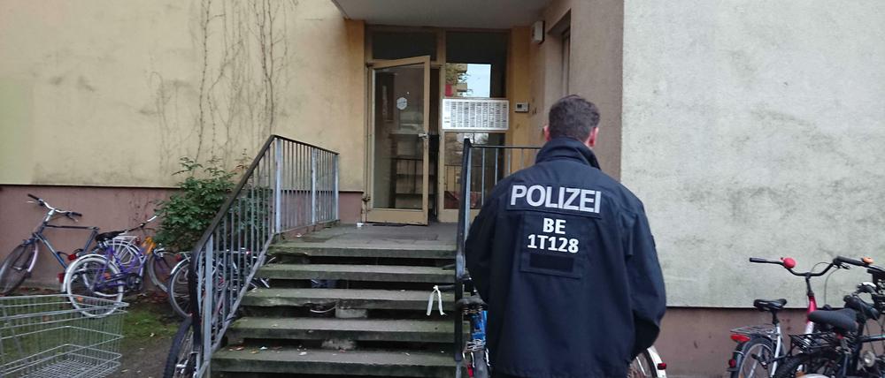 Ein Polizist steht vor dem Eingang des Wohnhauses, in dem der Terrorverdächtige lebte.