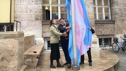Justizsenator Dirk Behrend (Mitte) beim Aufziehen der Transflagge.