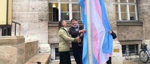 Justizsenator Dirk Behrend (Mitte) beim Aufziehen der Transflagge.
