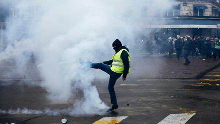 Ein Demonstrant wirft einen Tränengasbehälter während einer Demonstration der "Gelbwesten" weg. Genau ein Jahr nach Beginn der Proteste gibt es in Frankreich neue Demonstrationen.
