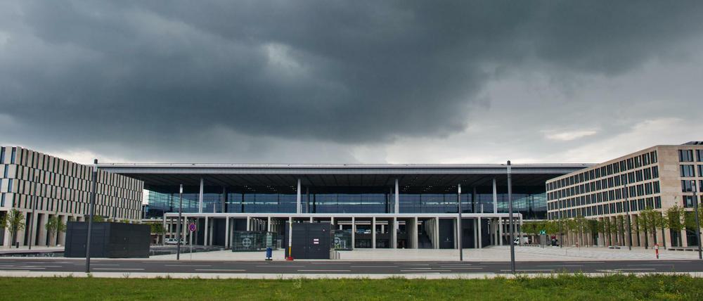 Dunkle Regenwolken liegen über dem Terminal des Flughafens Berlin-Brandenburg.