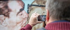 Bruderkuss. Das Bild an der East Side Gallery ist immer noch ein sehr beliebtes Motiv für Berlin-Besucher.