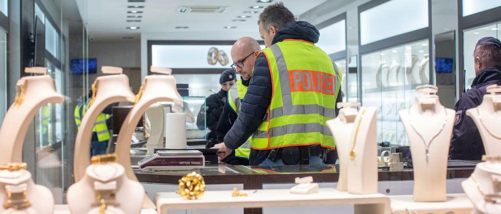Beamte durchsuchen die Räumlichkeiten eines Juweliers.