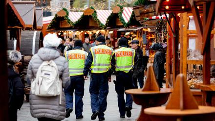 Berlin 2018: Drei Polizisten patrouillieren auf dem Weihnachtsmarkt am Breitscheidplatz.