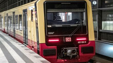 Die neue S-Bahn fährt in der Nacht durch einen Bahnhof.