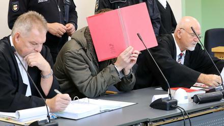 Ein Angeklagter mit seinen Verteidigern im Gericht. Der Vorwurf lautet: Mord.