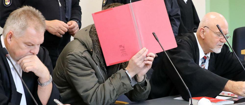 Ein Angeklagter mit seinen Verteidigern im Gericht. Der Vorwurf lautet: Mord.