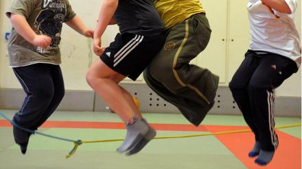In einer Sporthalle nehmen übergewichtige Kinder an einem Sportprogramm teil.