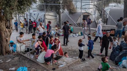 Menschen stehen um eine Wasserstelle und befüllen Flaschen im Flüchtlingslager Moria auf der griechischen Insel Lesbos. 