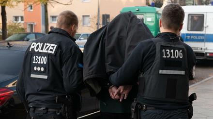 Polizeibeamte nehmen einen Verdächtigen bei einer Razzia in Tempelhof fest. 