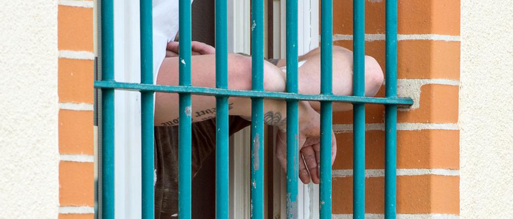 Ein Häftling der Justizvollzugsanstalt (JVA) Wriezen steht an seinem vergitterten Fenster.