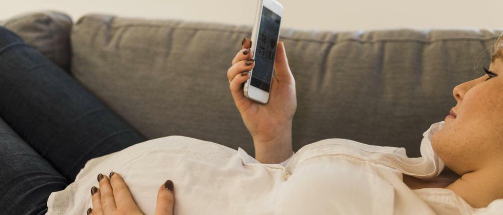 Eine schwangere Frau nutzt ihr Smartphone - ist das bereits gefährlich?
