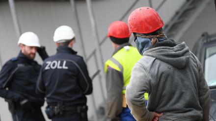 Schwarzarbeit oder zu wenig gezahlt? Zollbeamte kontrollieren eine Baustelle. 